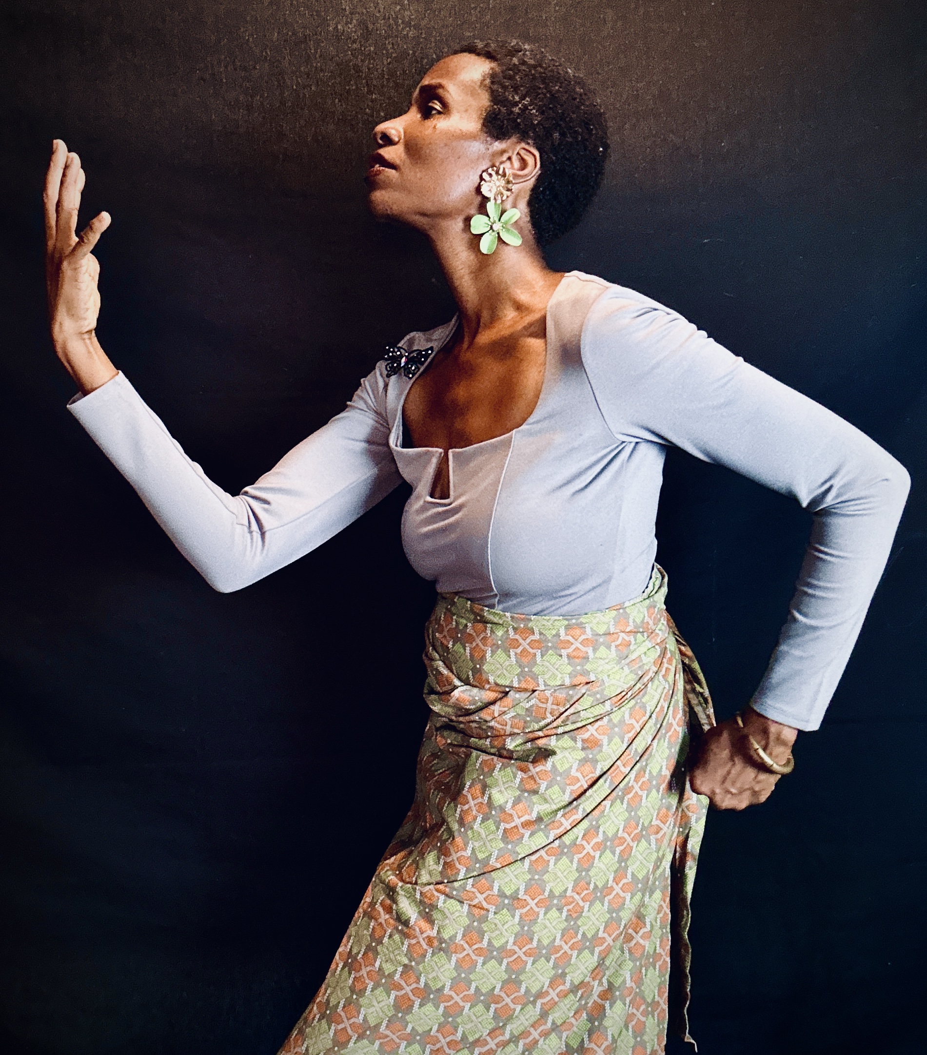 Alexis Joi in a studio portrait with one hand raised